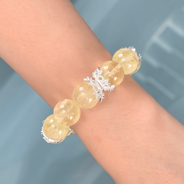 Yellow crystal bead bracelet with silver crown spacers worn on wrist
