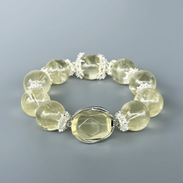 Yellow Azeztulite crystal bead bracelet on a gray background