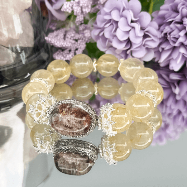 Golden Rutilated Quartz bracelet displayed on a reflective surface.