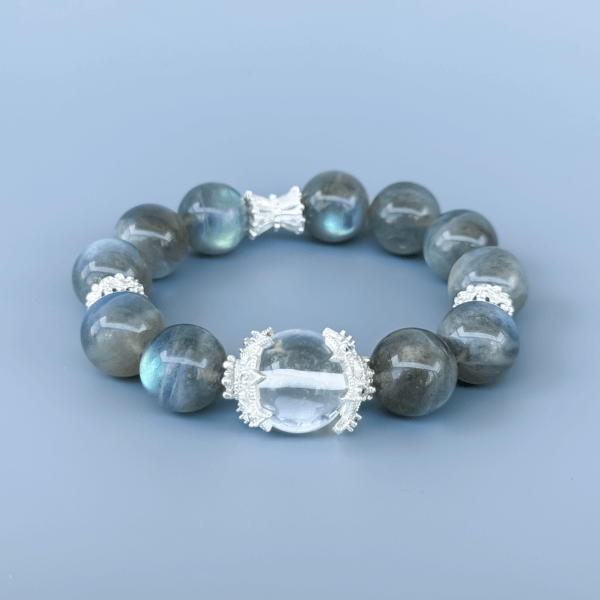Gray Moonstone crystal bead bracelet with clear center on a blue background.