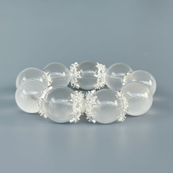 Milky White Crystal Bead Bracelet with Silver Details on a Plain Background