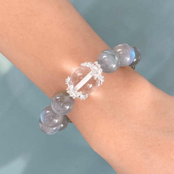 Gray Moonstone crystal bead bracelet with a clear central bead on wrist.