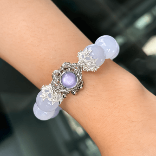 Blue Chalcedony bracelet worn on the wrist with a purple pendant and silver spacers