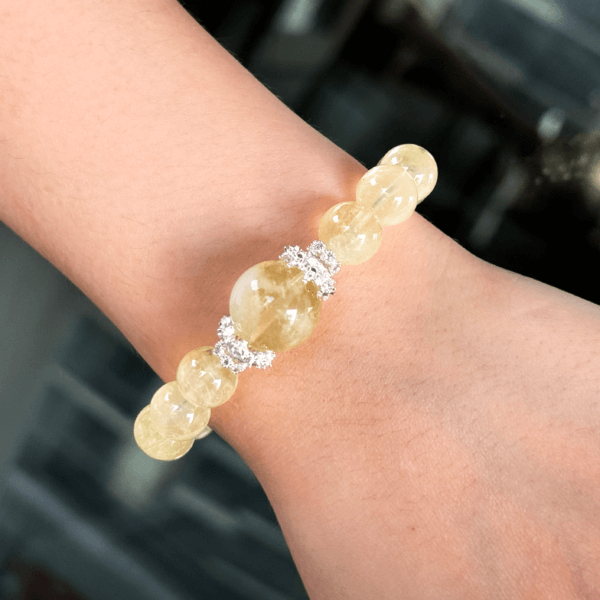 Yellow crystal bracelet on wrist with silver accents