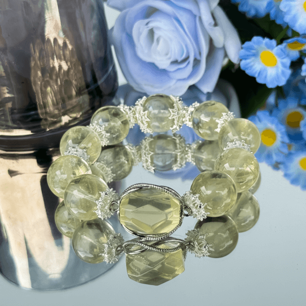 Yellow Azeztulite crystal bead bracelet displayed with flowers