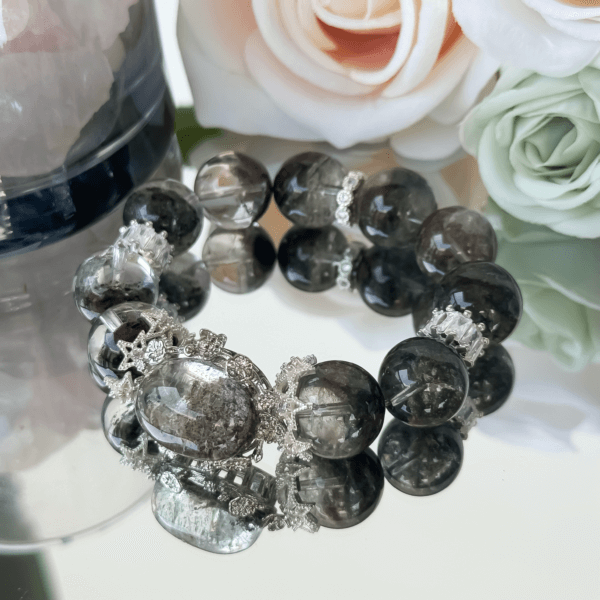 Green Ghost Phantom crystal bead bracelet displayed with roses and silver embellishments