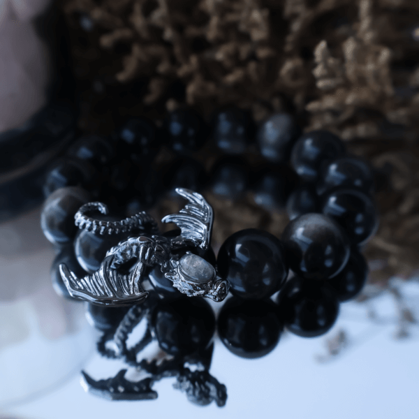 Obsidian crystal bead bracelet with dragon charm close-up