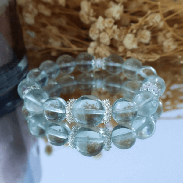 Green Fluorite crystal bead bracelet with reflective surface display.