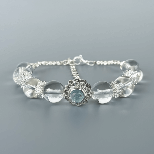 Clear Quartz Bracelet with Floral Silver Centerpiece on Grey Background