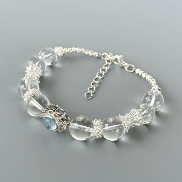 Clear Quartz Bracelet with Floral Silver Centerpiece on Grey Background