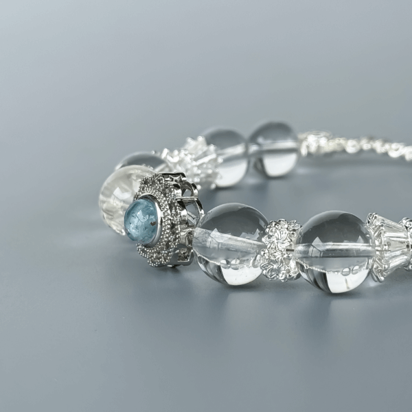 Clear Quartz Bracelet with Floral Silver Centerpiece on Grey Background