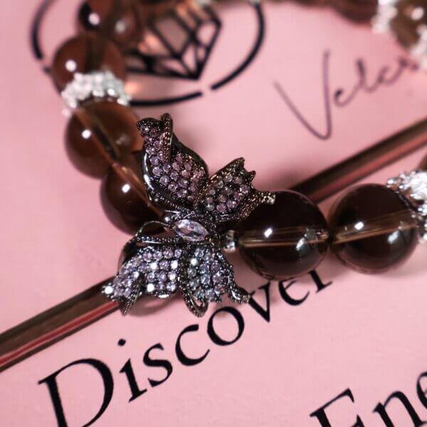 Butterfly charm detail on smoky quartz crystal bracelet