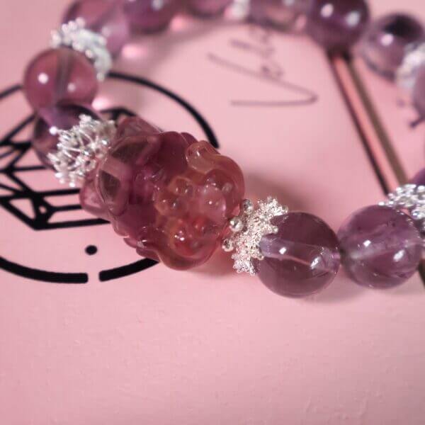Purple crystal bracelet with red carved charm and silver accents.