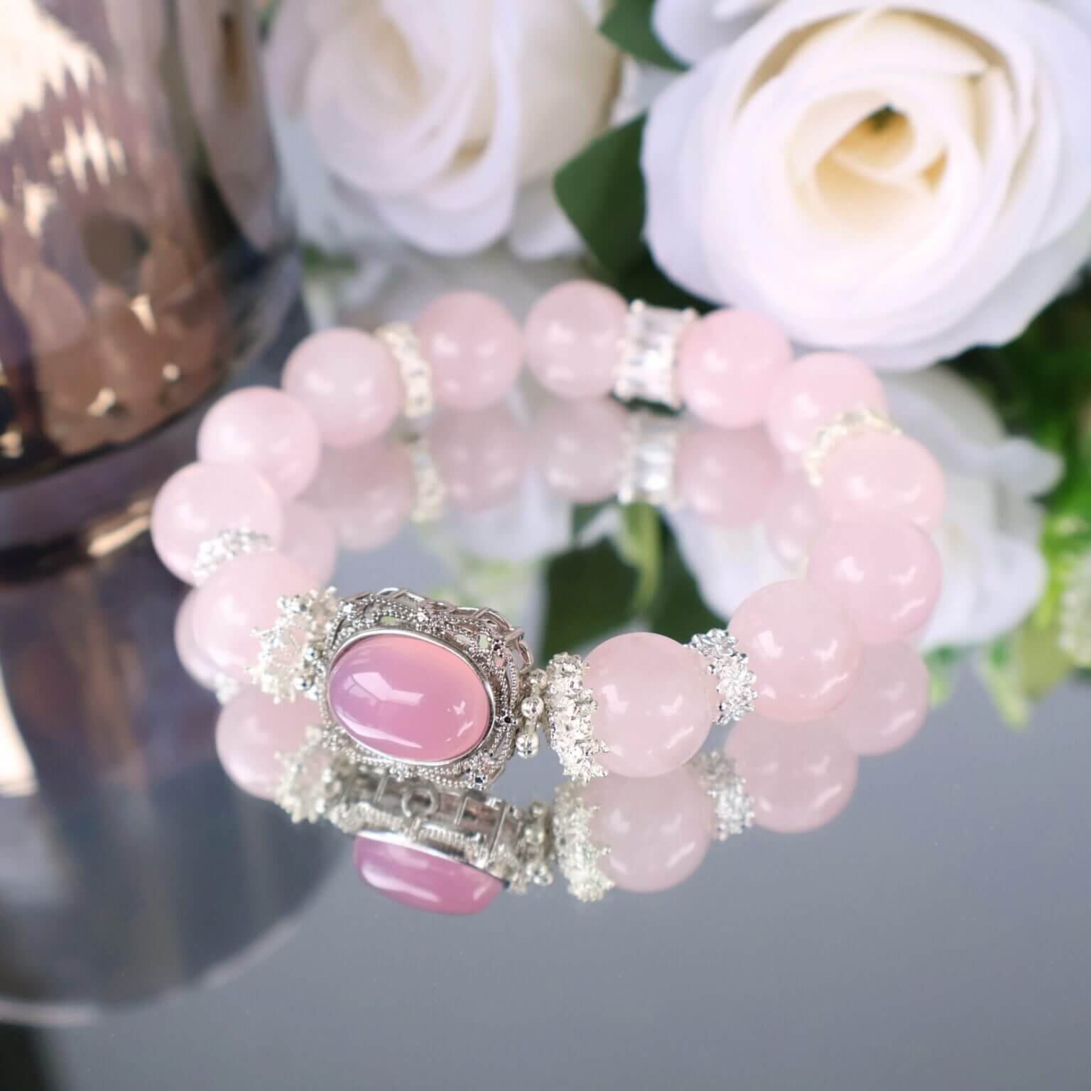 Handmade pink crystal bracelet displayed with roses