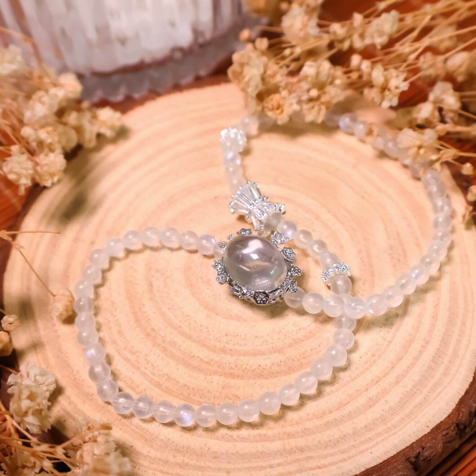 Blue moonstone bracelet with silver accents displayed on wood.