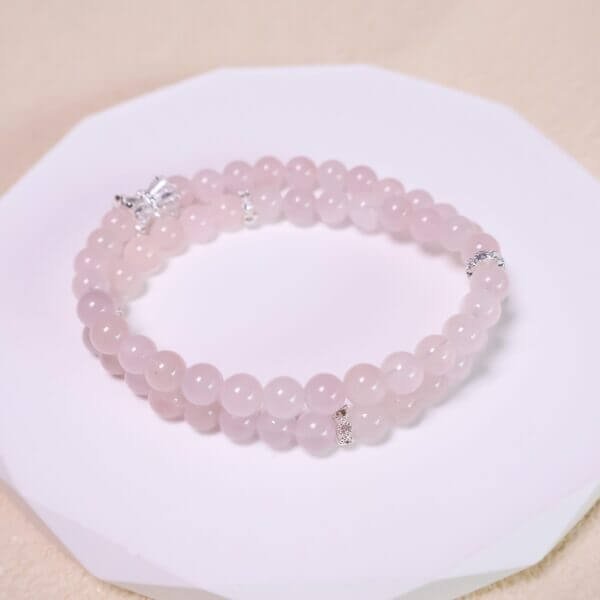 Rose quartz bracelet with double-strand layout on white background