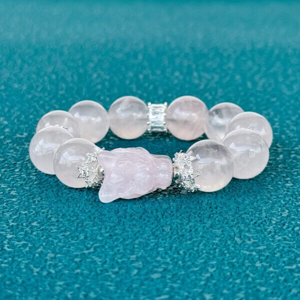 Handmade rose quartz crystal bracelet with carved bead and silver accents