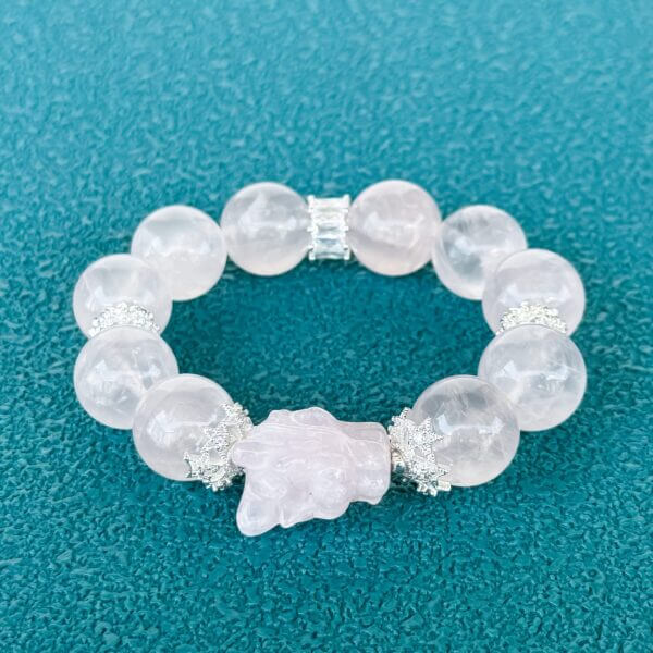 Handmade rose quartz crystal bracelet with carved bead and silver accents