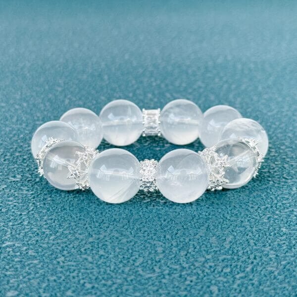 Milk white crystal bead bracelet with silver accents on teal background